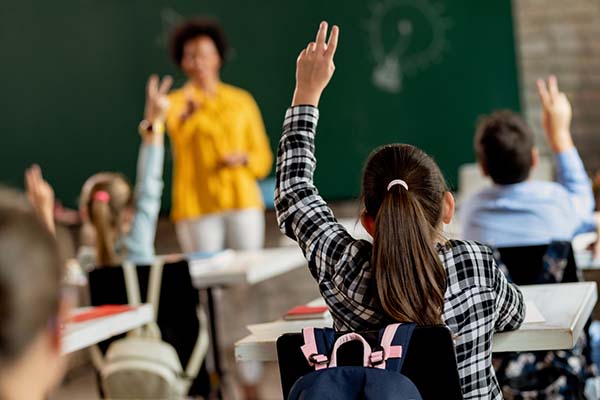 girl raising hand in classroom